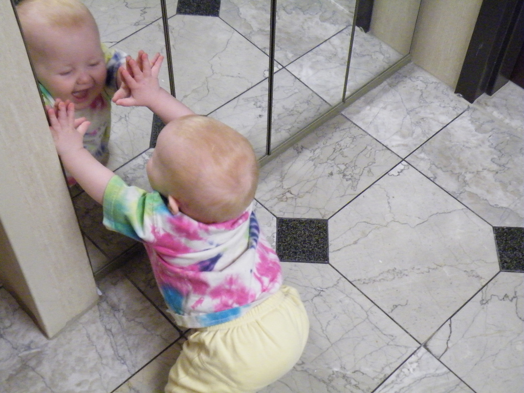 baby touching mirror