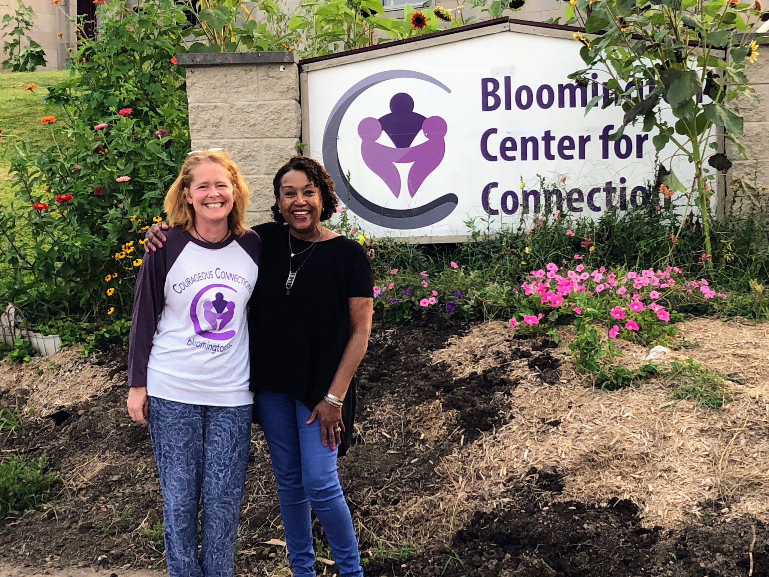 Maureen Walker and Amy Makice stand in front of the Bloomington Center for Connection sign